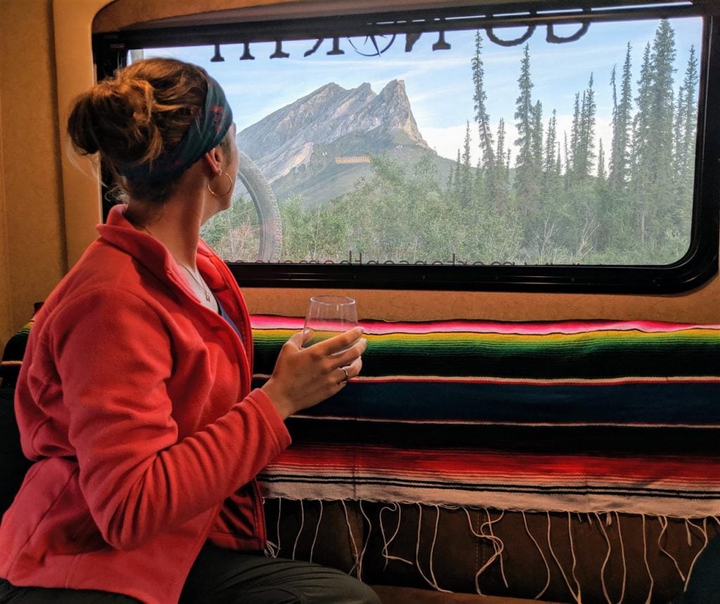 using the rear couch of the truck camper to relax and enjoy the mountain view