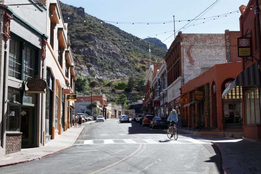Woman bicycling through the main street of Bisbee, Arizona