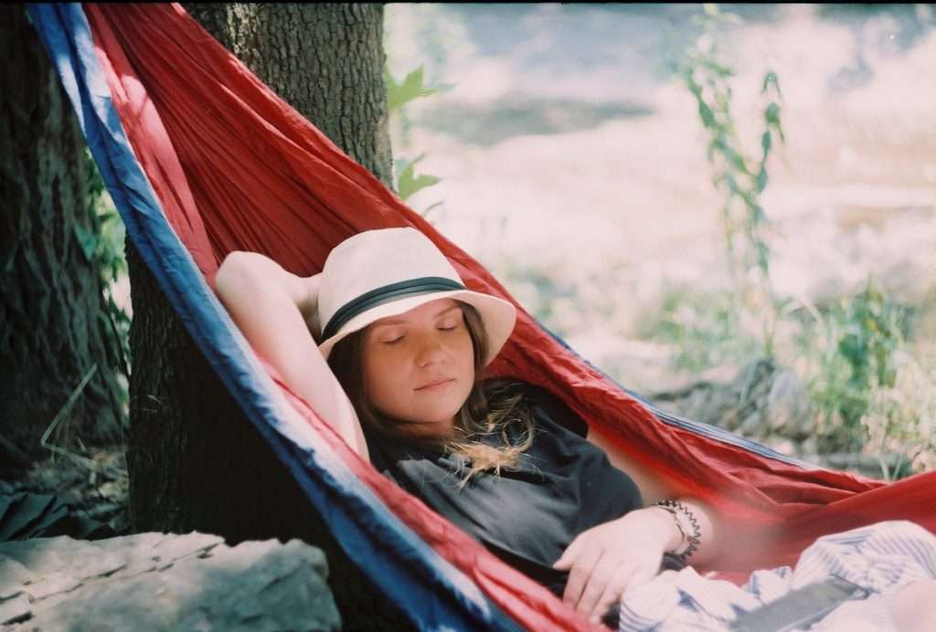girl sleeping in hammock while camping