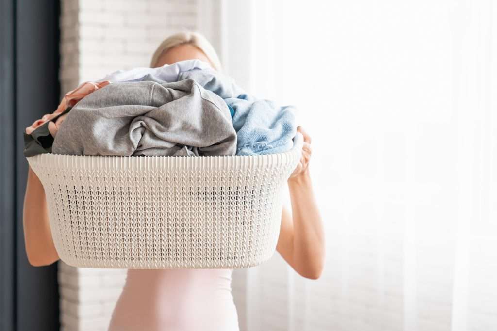 Woman holding a basket of clean laundry.